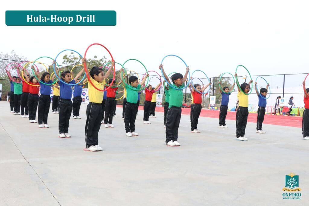 students do hula hoop drill activity on playground of school
